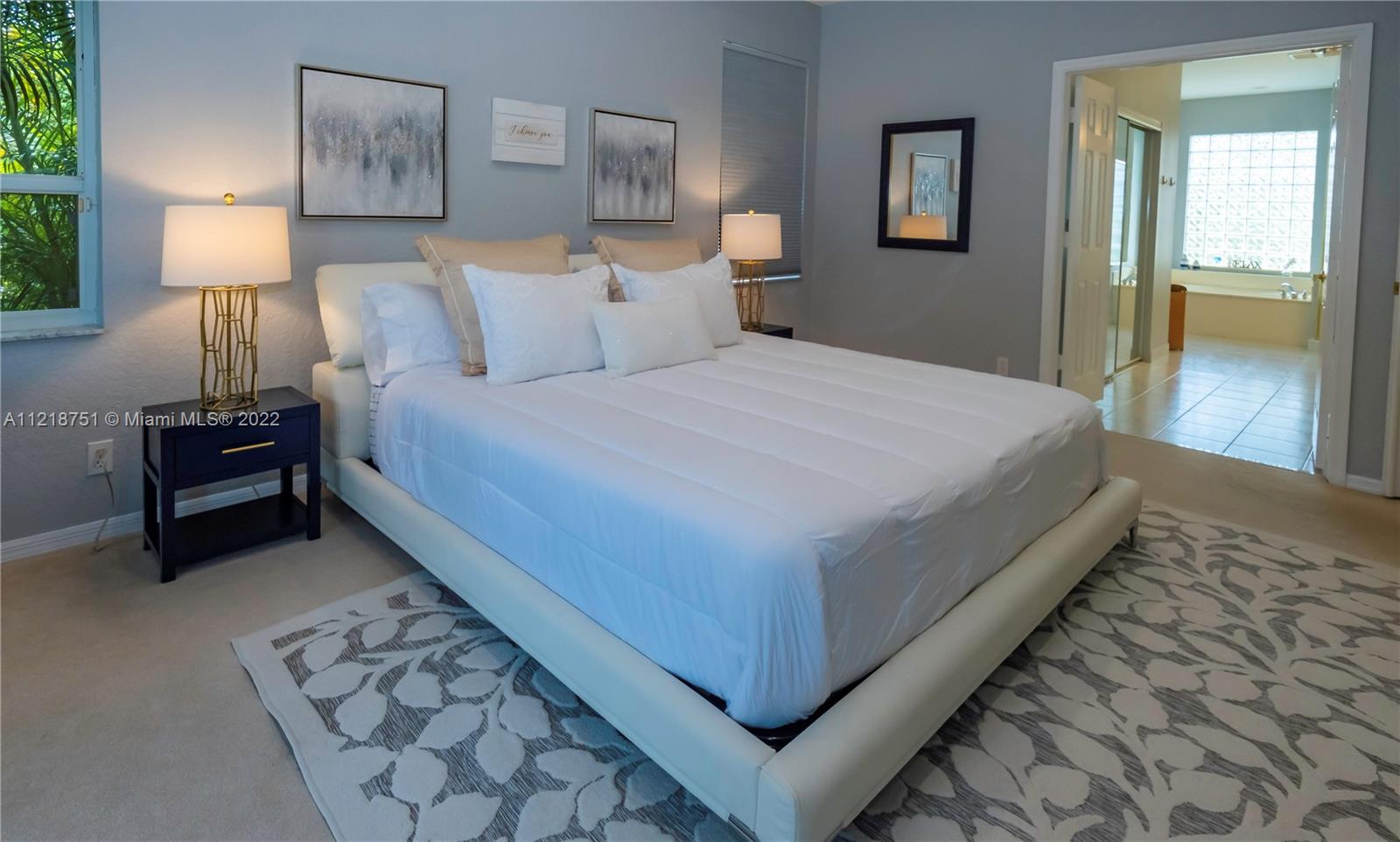 21432 Gosier Way Boca Raton, FL 33428 - Photo 34 of 55 a bedroom with a bed and lamp