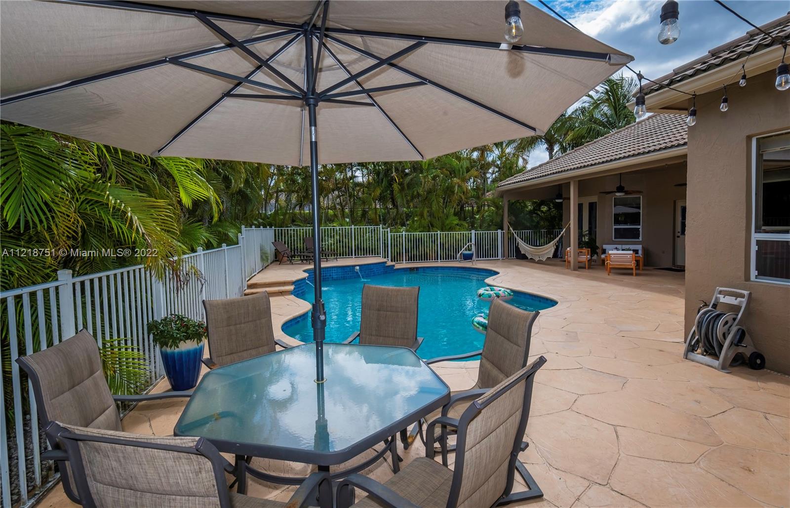 21432 Gosier Way Boca Raton, FL 33428 - Photo 48 of 55 a patio with a table and chairs under an umbrella
