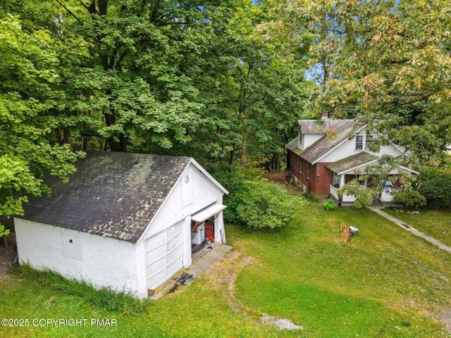 an aerial view of a house with a yard table and chairs