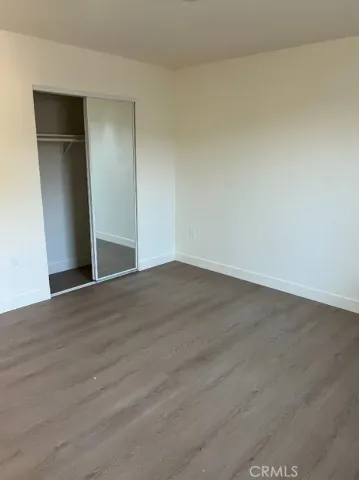an empty room with wooden floor and closet