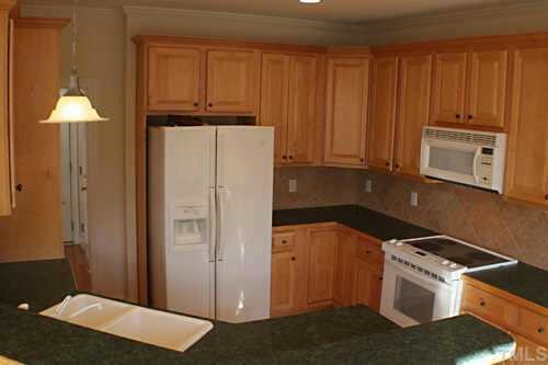7220 Summit Waters Lane Raleigh, NC 27613 - Photo 4 of 11 a kitchen with a refrigerator stove and cabinets