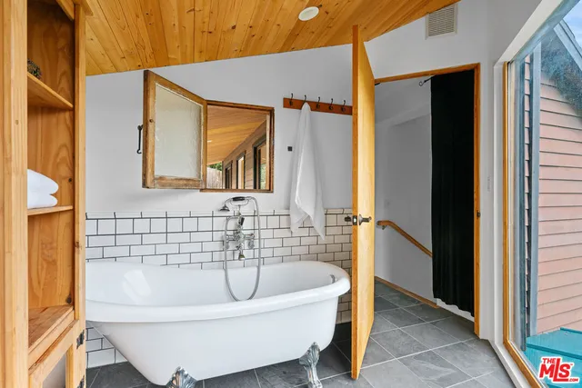 a bathroom with a sink and mirror with bathtub