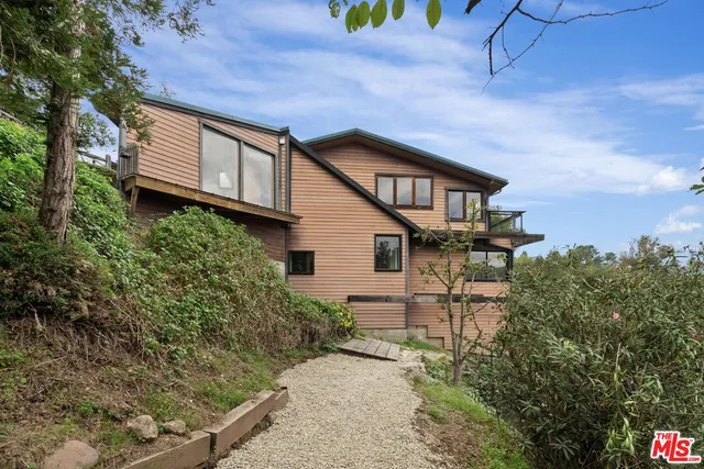 an aerial view of a house with swimming pool and garden