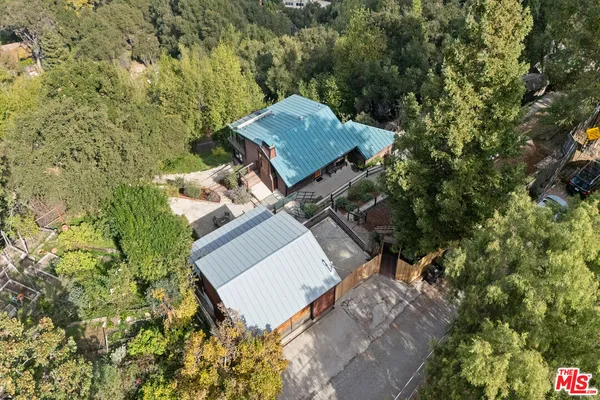 a view of a house with a backyard and trees