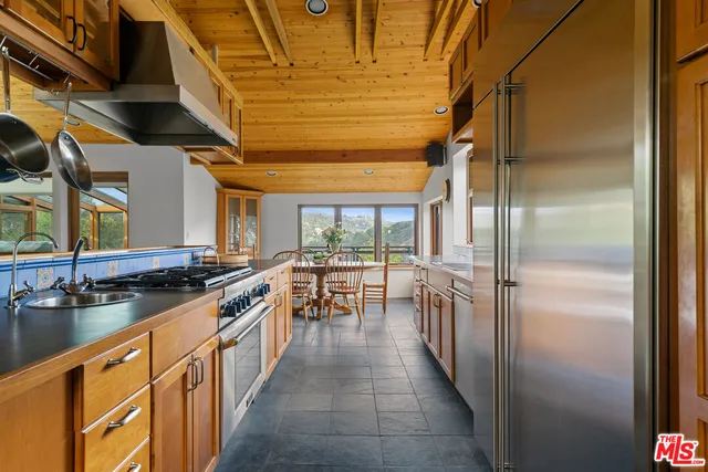 a kitchen with stainless steel appliances granite countertop a sink and a refrigerator