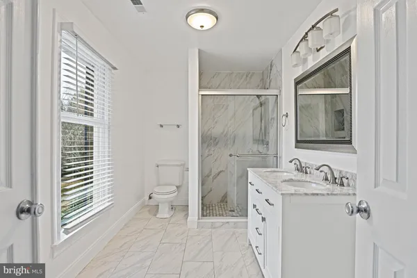 a bathroom with a sink a toilet and shower