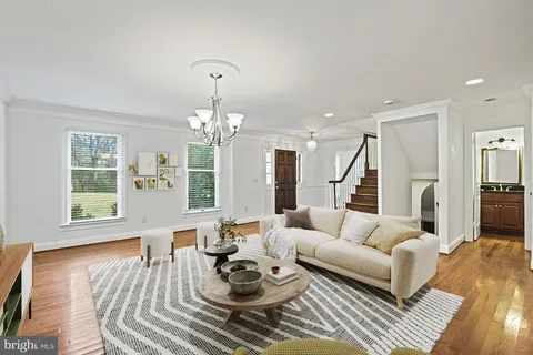 a living room with furniture wooden floor and a chandelier