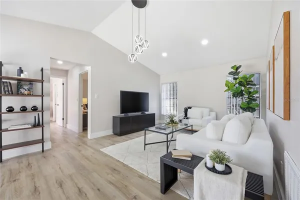 a living room with furniture a chandelier and a flat screen tv
