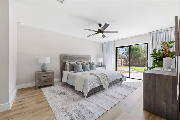 a spacious bedroom with a large bed and a chandelier