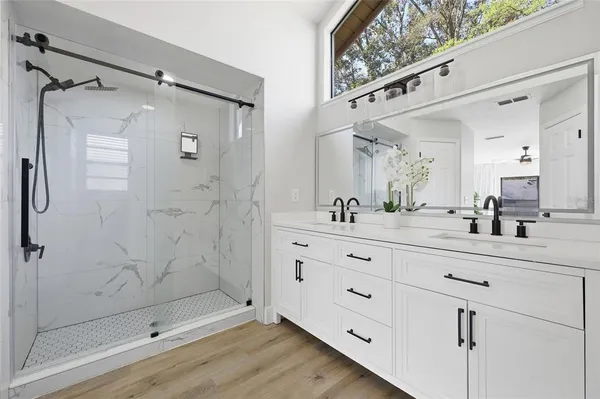a bathroom with a shower sink and mirror