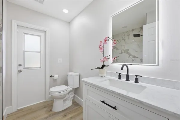 a bathroom with a sink a toilet and a mirror