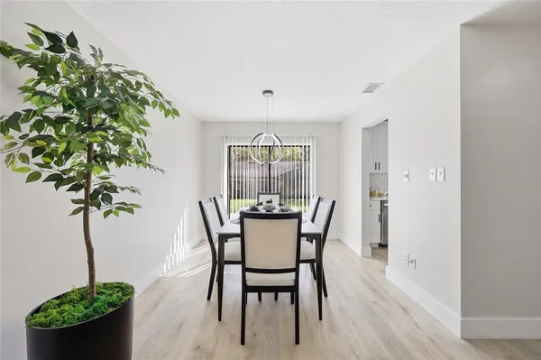 a dining room with furniture potted plants and wooden floor