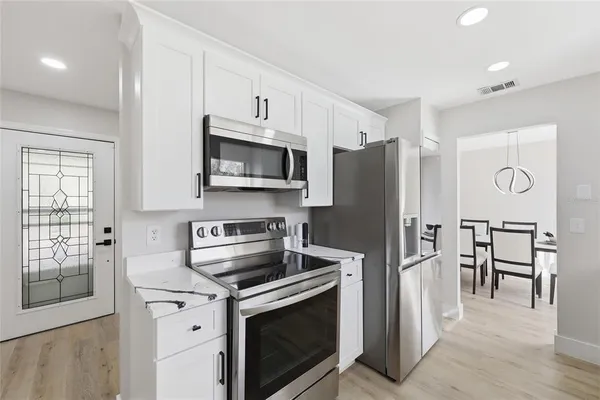 a kitchen with stainless steel appliances a stove microwave and refrigerator