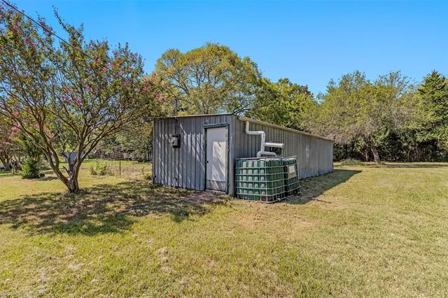 an aerial view of residential houses with outdoor space and trees all around