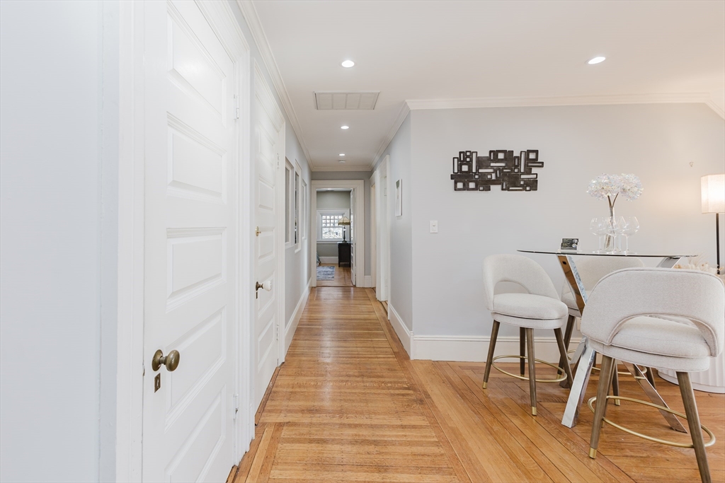 159 Washington Street, Unit 4 Newton, MA 02458 - Photo 38 of 42 a view of a hallway with wooden floor and chairs