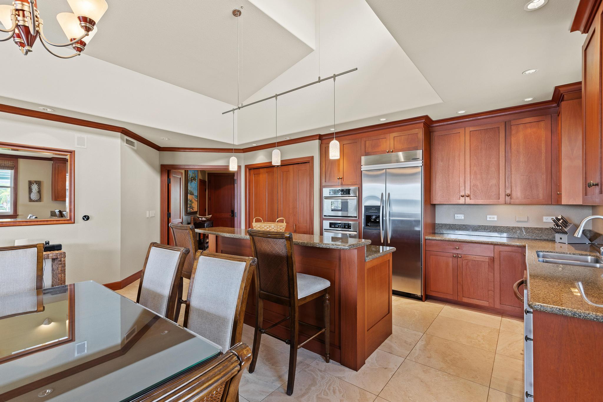 69-1000 Kolea Kai Circle, Unit 11C Waikoloa, HI 96738 - Photo 6 of 30 a dining hall with stainless steel appliances granite countertop a stove a sink dishwasher and cabinets with wooden floor
