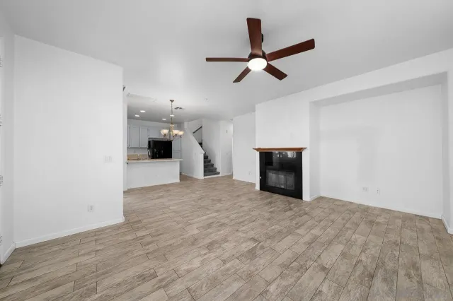 a view of a livingroom with a ceiling fan and wooden floor