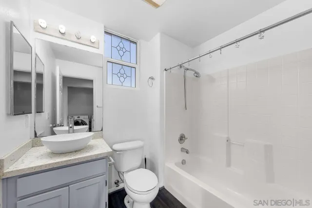 a bathroom with a granite countertop sink toilet and shower