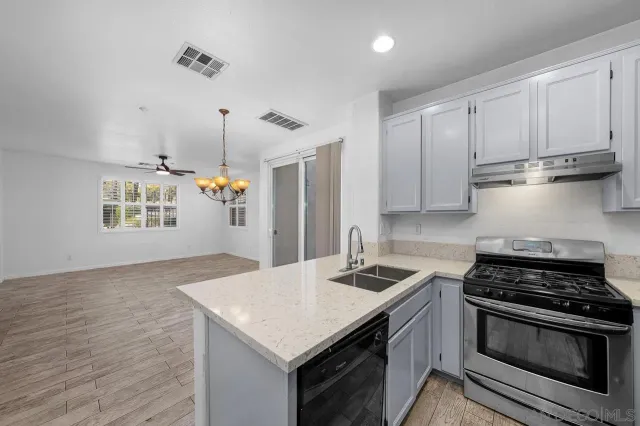 a kitchen with granite countertop a sink stove and cabinets