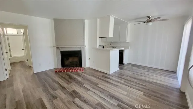 a view of empty room with wooden floor and fireplace