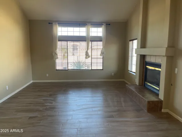 a view of empty room with wooden floor and fireplace