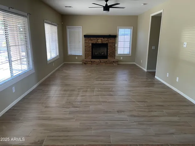 wooden floor fireplace and windows in an empty room