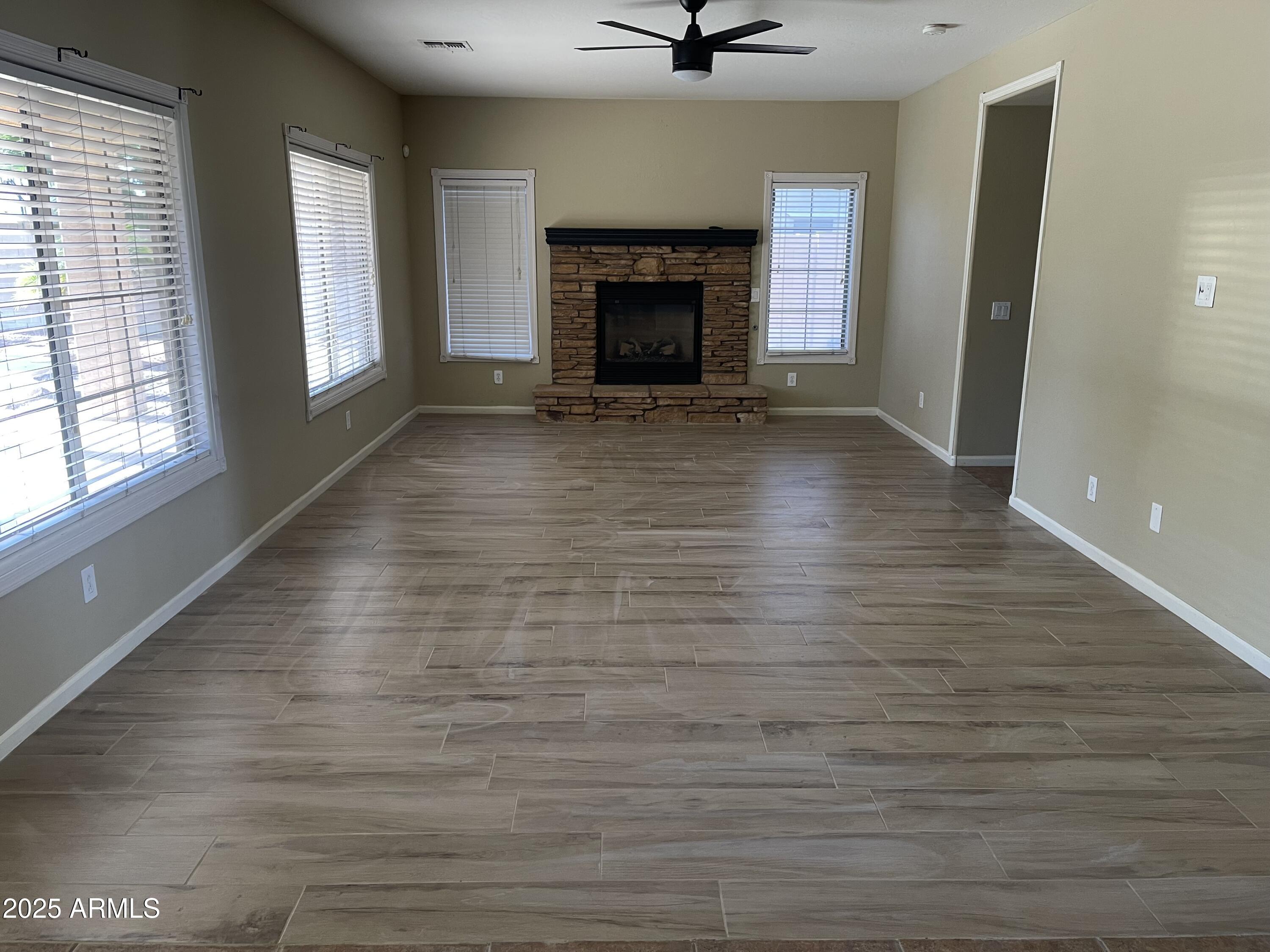 3235 East Devonshire Court Gilbert, AZ 85297 - Photo 12 of 28 wooden floor fireplace and windows in an empty room