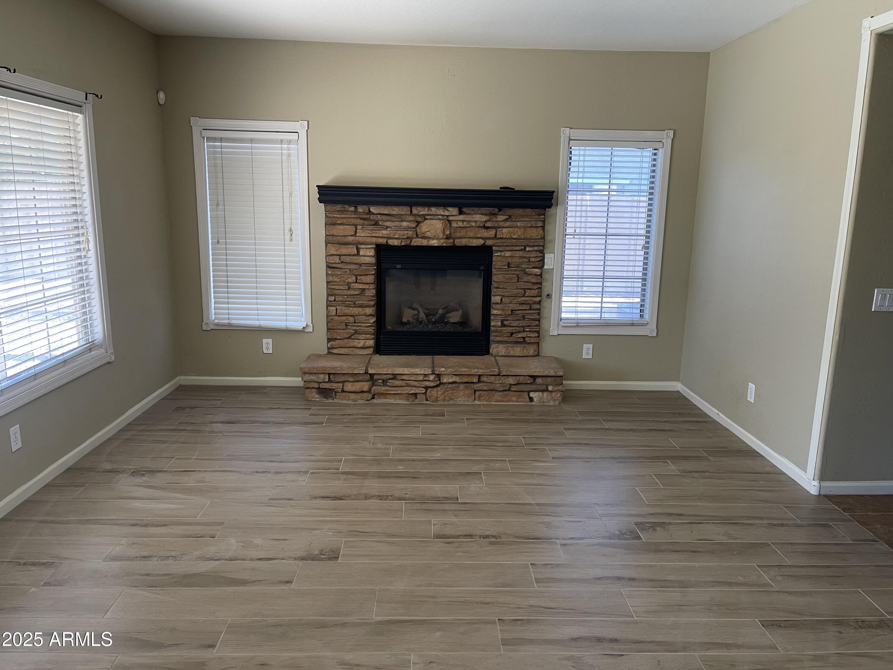 3235 East Devonshire Court Gilbert, AZ 85297 - Photo 13 of 28 a view of empty room with wooden floor and fireplace