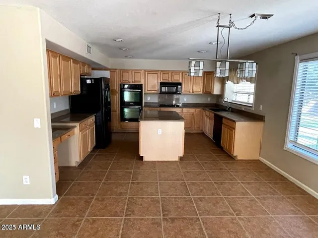 a kitchen with a sink a counter top space appliances and cabinets