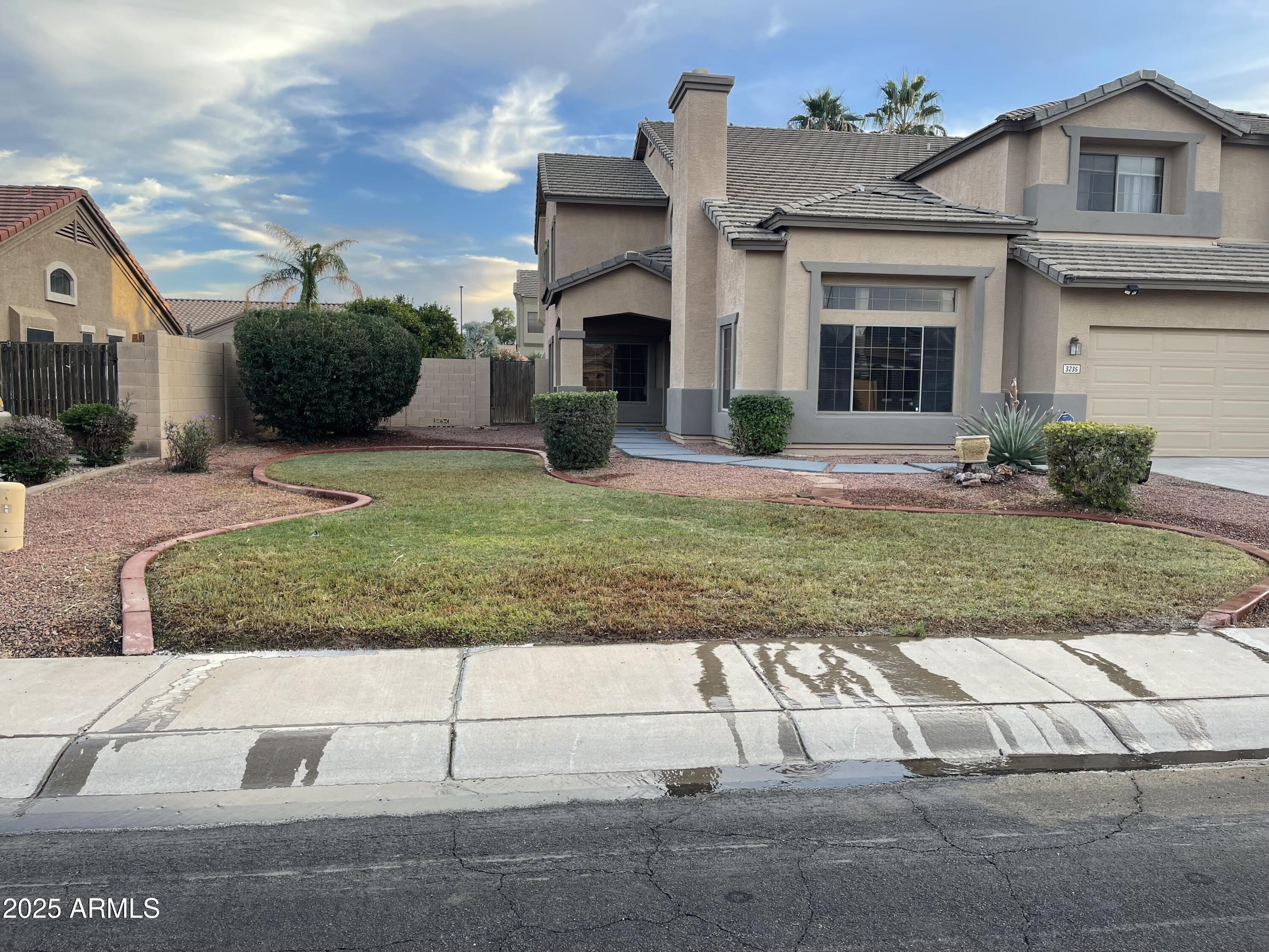 3235 East Devonshire Court Gilbert, AZ 85297 - Photo 28 of 28 a view of a white house with a yard in front of it