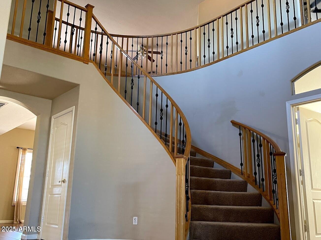 3235 East Devonshire Court Gilbert, AZ 85297 - Photo 7 of 28 a view of staircase with lots of frames on wall and wooden floor