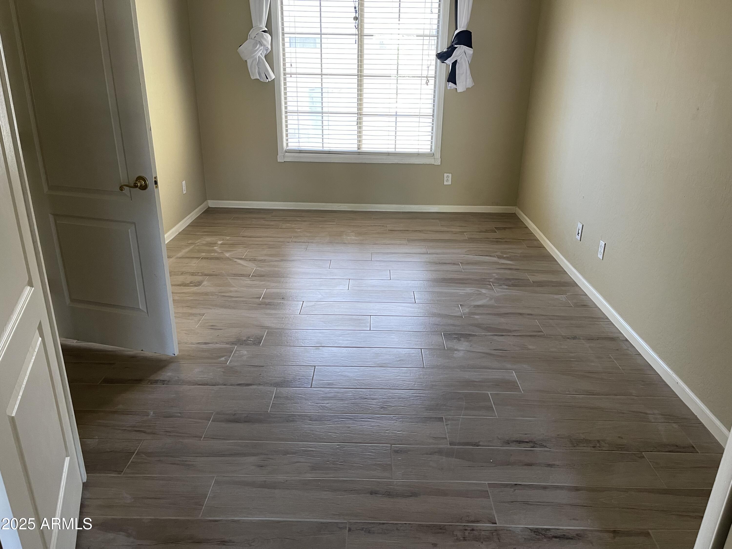 3235 East Devonshire Court Gilbert, AZ 85297 - Photo 8 of 28 an empty room with wooden floor and windows