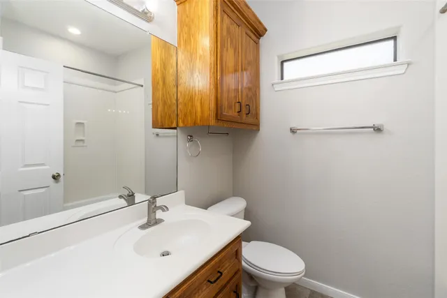 a bathroom with a sink a toilet and shower