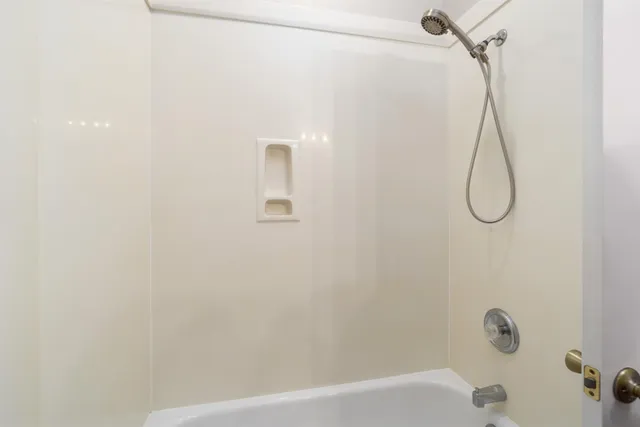 a bathroom with a bath tub with a shower