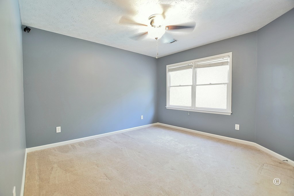 8935 K Moore Road Columbus, GA 31904 - Photo 26 of 36 an empty room with windows and ceiling fan