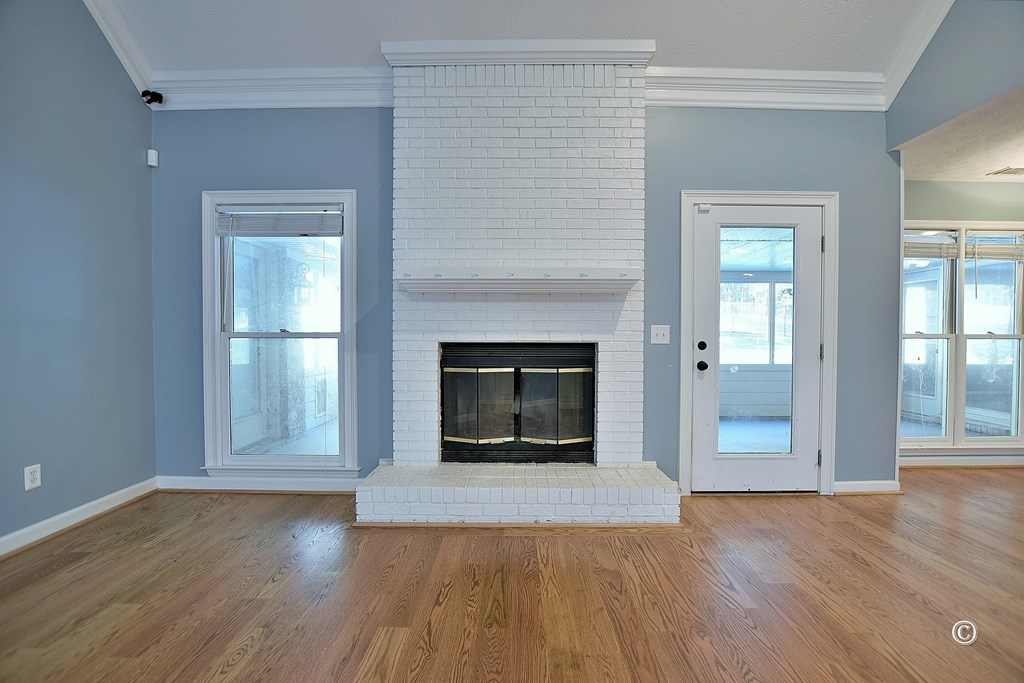 8935 K Moore Road Columbus, GA 31904 - Photo 5 of 36 an empty room with wooden floor and fireplace