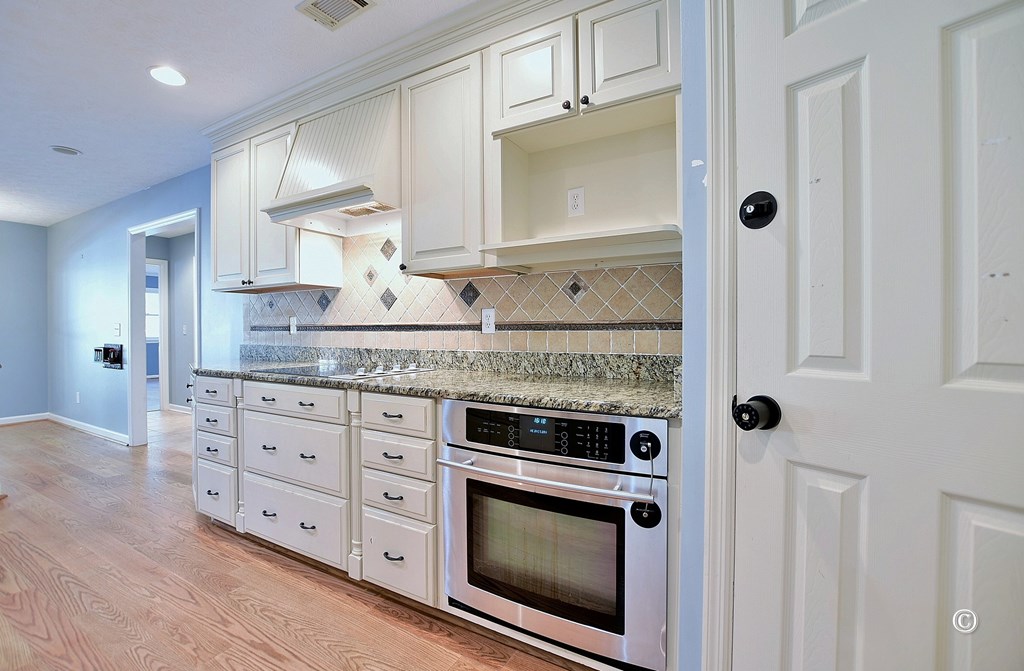 8935 K Moore Road Columbus, GA 31904 - Photo 10 of 36 a kitchen with granite countertop a stove microwave and cabinets