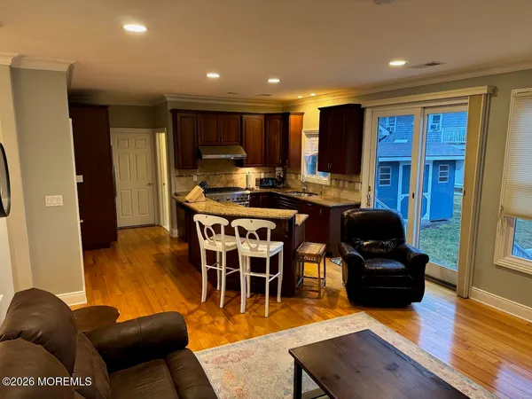 a view of a dining room with furniture a kitchen and chandelier