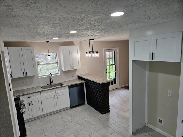 a kitchen with a sink refrigerator and cabinets
