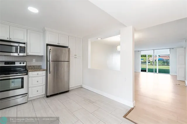 a kitchen with a refrigerator and a stove top oven