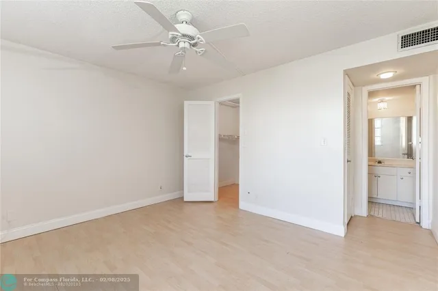 an empty room with fan and entrance