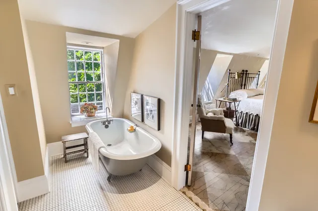 a living room with furniture large window and wooden floor