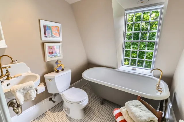 a view of house with a big yard potted plants and large tree