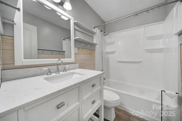 a bathroom with a double vanity sink toilet mirror and shower