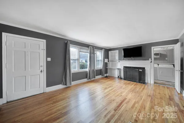 a view of a livingroom with a fireplace a ceiling fan and windows