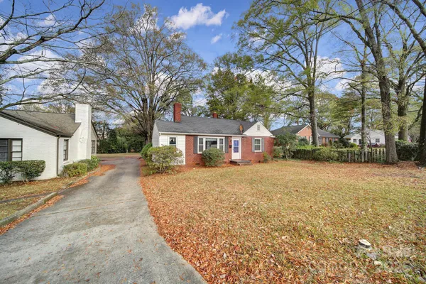 a view of a house with a yard and large tree