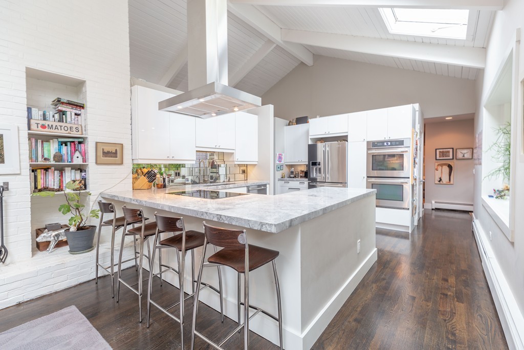 140 Whiting Street Hingham, MA 02043 - Photo 8 of 25 a kitchen with a table chairs refrigerator and a sink