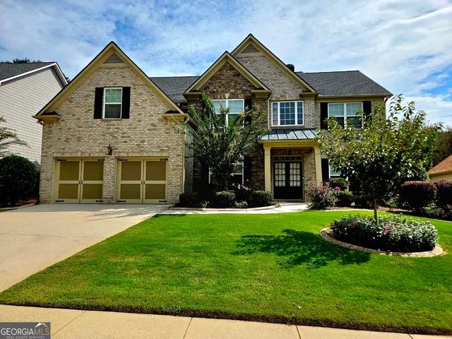 a front view of a house with a yard and garage