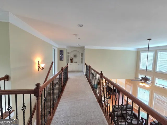 a view of a hallway with wooden floor and staircase