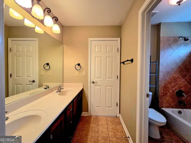 a spacious bathroom with a double vanity sink a mirror and a bathtub